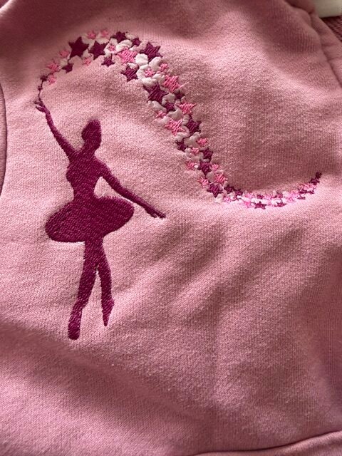 Sweat rose brodé d'une danseuse et d'une traînée d'étoiles